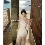 現貨+預購🔗 【𝐊𝐈𝐊𝐈𝐅𝐀𝐌𝐄】🕊️絕美女神渡假鏤空斜肩長洋裝 白色洋裝 開衩長裙 渡假洋裝 A字洋裝 露腰連身裙
